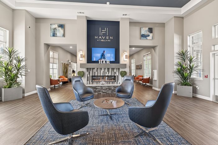 Inviting lounge area featuring stylish armchairs and a modern fireplace at Haven at Bellaire, perfect for relaxation and social gatherings.
