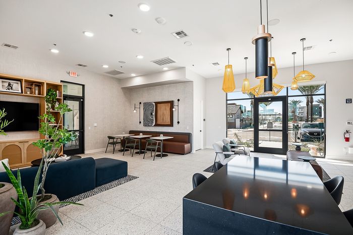 Modern communal area with stylish seating, artistic decor, and ample natural light, perfect for social gatherings or relaxation.