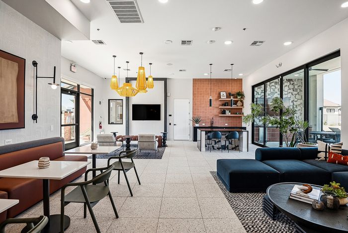 Chic and modern lounge area with ample seating, stylish lighting fixtures, and natural light streaming through expansive windows.