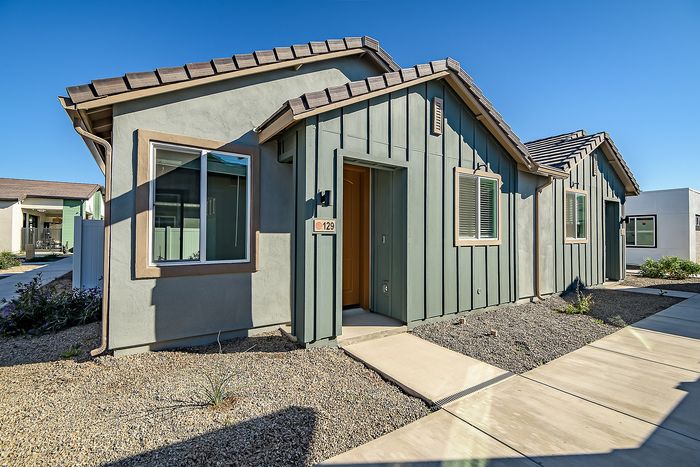 Charming single-story home with modern facade, welcoming entrance, and bright windows surrounded by a tidy landscape.