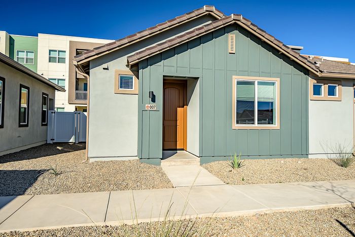 Charming single-story home with modern facade and inviting entryway, nestled in a tranquil neighborhood setting.