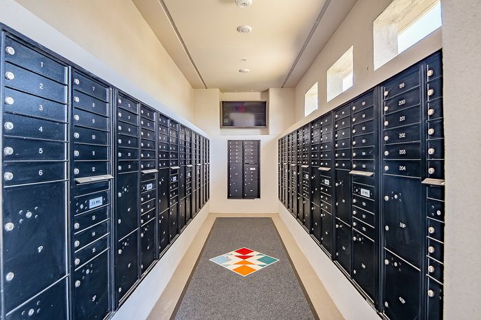 Modern mail room with sleek black mailboxes and bright natural light, offering a secure and stylish mail solution.