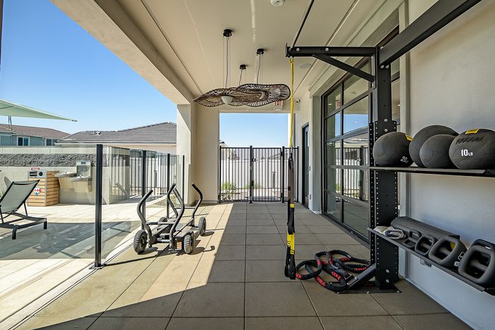Modern outdoor fitness area with weight equipment, sleek design, and ample sunlight, ideal for a healthy lifestyle.