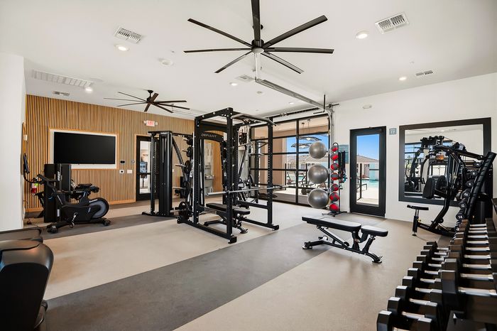 Modern gym with sleek equipment, multifunctional workout stations, and large windows for natural light.