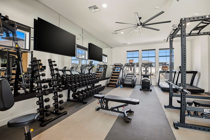 Modern fitness center featuring state-of-the-art equipment, sleek design, and ample natural light.