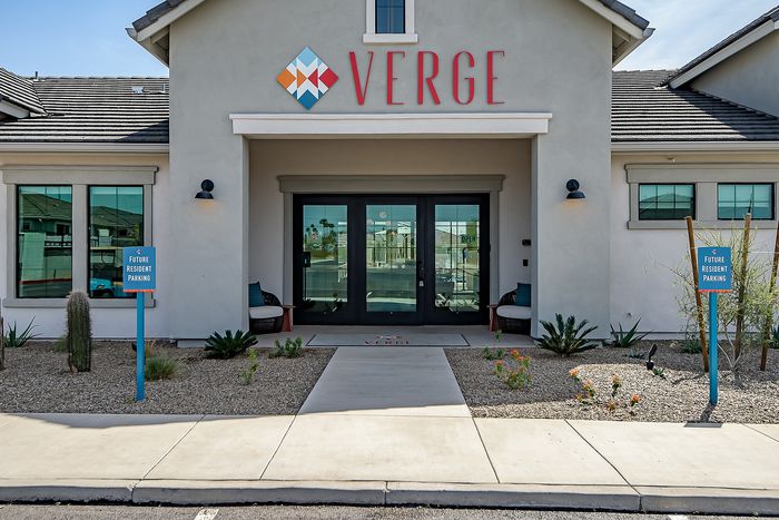 Inviting entrance to Verge apartments featuring modern design, welcoming seating, and future resident parking.