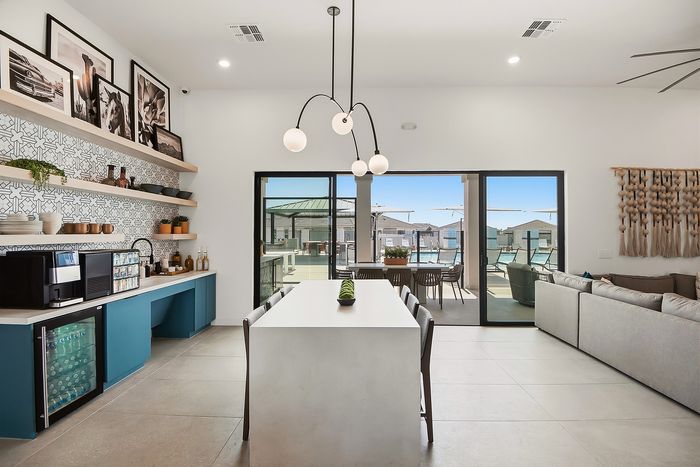 Chic open-concept living space with a modern kitchen, elegant dining area, and vibrant outdoor patio view.