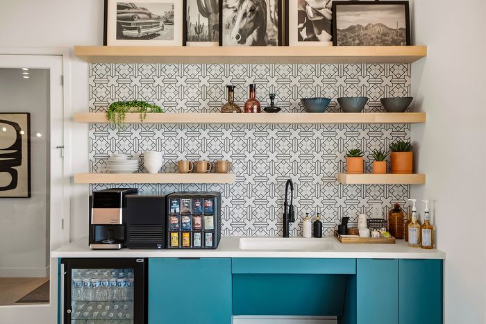 Chic modern kitchenette with stylish geometric tile backsplash, open wooden shelves, trendy decor, and a sleek coffee station.