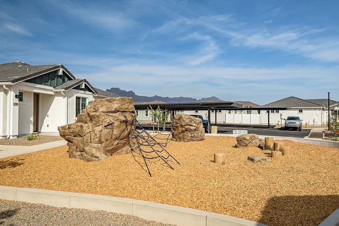 Inviting playground with modern climbing structure and scenic mountain views, nestled in a charming residential community.