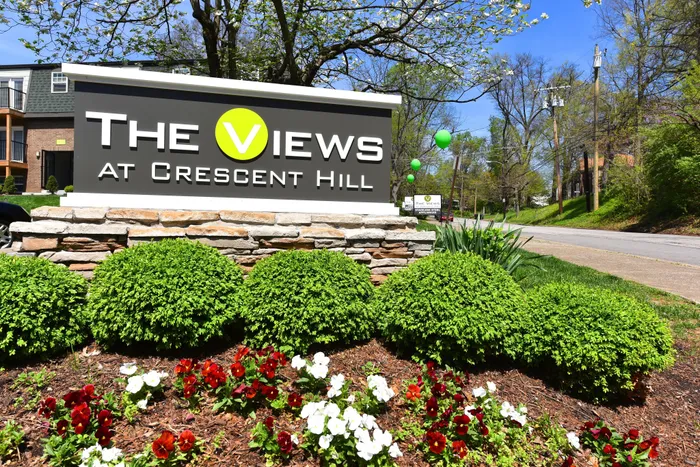 Inviting exterior of The Views at Crescent Hill with vibrant landscaping and a welcoming entrance.