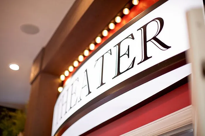 Elegant theater sign with bright marquee lights, creating a welcoming and luxurious ambiance.