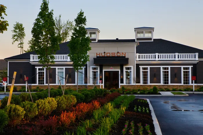 Elegant exterior of the Hudson apartment complex with lush landscaping and classic architectural design, showcasing inviting curb appeal.