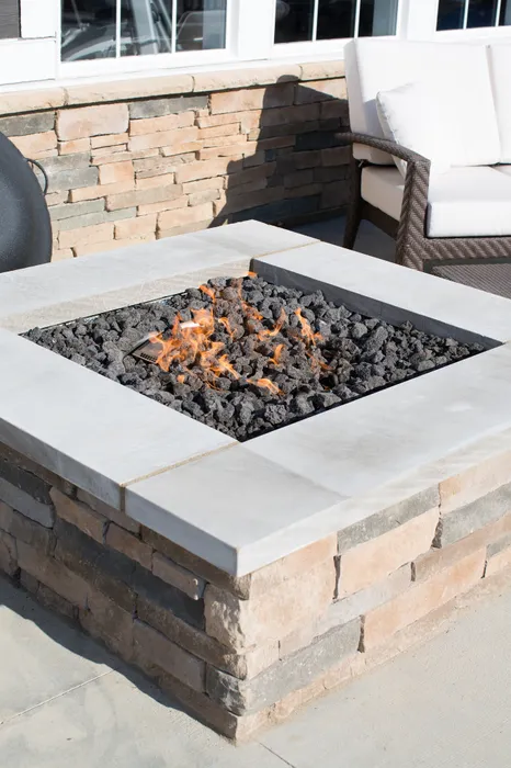 Inviting outdoor patio with a modern stone fire pit, perfect for cozy evenings.