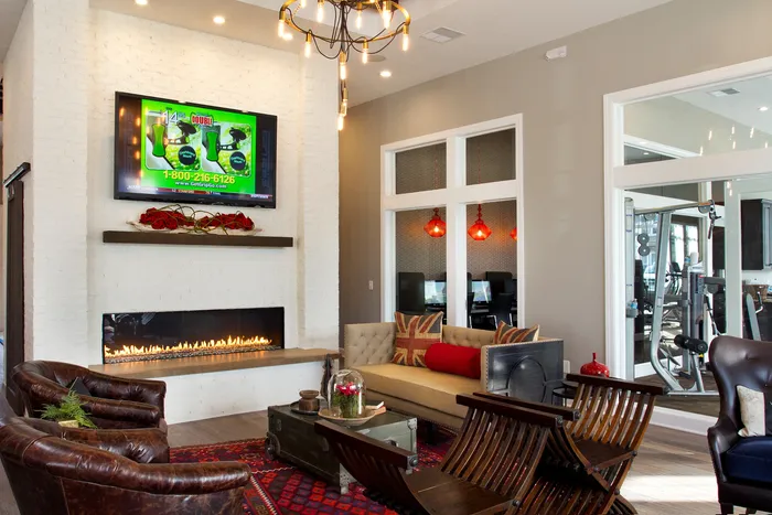 Sophisticated lounge area featuring a cozy modern fireplace, stylish seating with chic leather chairs, and elegant ambient lighting.