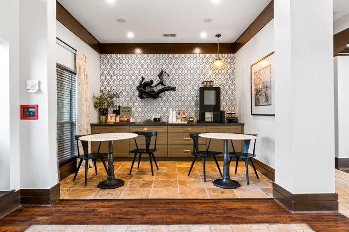 Chic café nook with stylish hexagonal patterned wall, modern decor, and cozy seating in a vibrant apartment setting.
