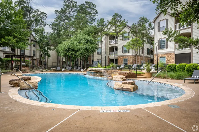 Tranquil apartment complex with a sparkling pool, surrounded by lush greenery and modern architecture, offering a serene and luxurious living experience.