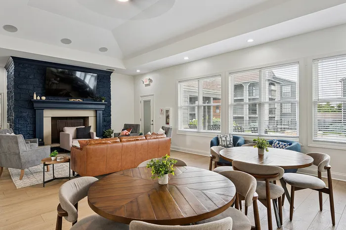 Elegant lounge area showcasing a contemporary design with a cozy leather sofa, armchairs, a stylish fireplace, and large windows offering natural light.