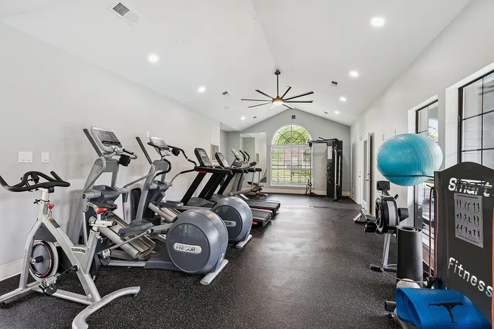 Contemporary fitness center featuring state-of-the-art cardio machines, strength training equipment, and bright atmospheric lighting.