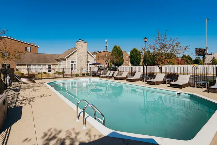 Inviting outdoor pool area with sun loungers and lush greenery, perfect for relaxation and enjoyment.
