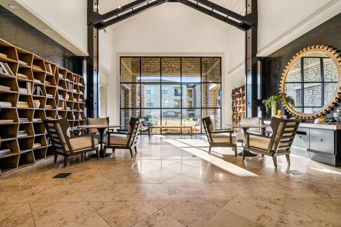 Elegant lounge area with high ceilings, large windows, and comfortable seating, perfect for relaxation and social gatherings.