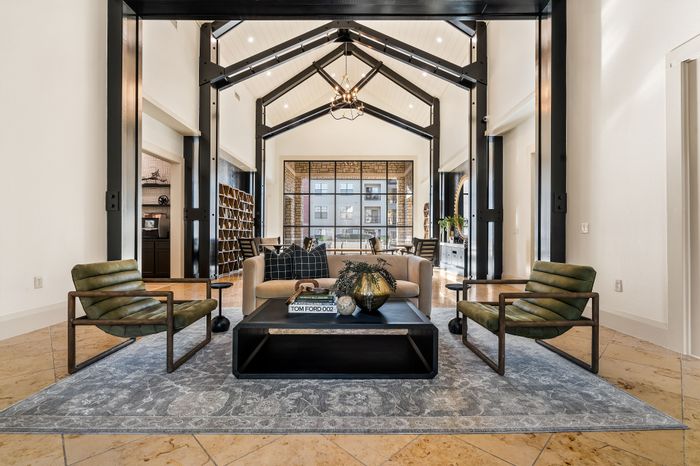 Luxurious open-concept living room with high ceilings, modern decor, and inviting natural light, ideal for relaxation and entertaining.