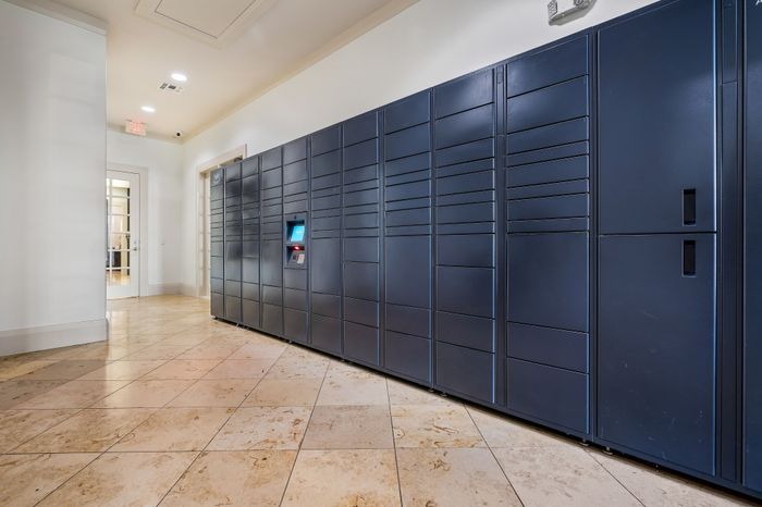 Modern package locker system in stylish apartment hallway with sleek tile flooring and secure access technology.