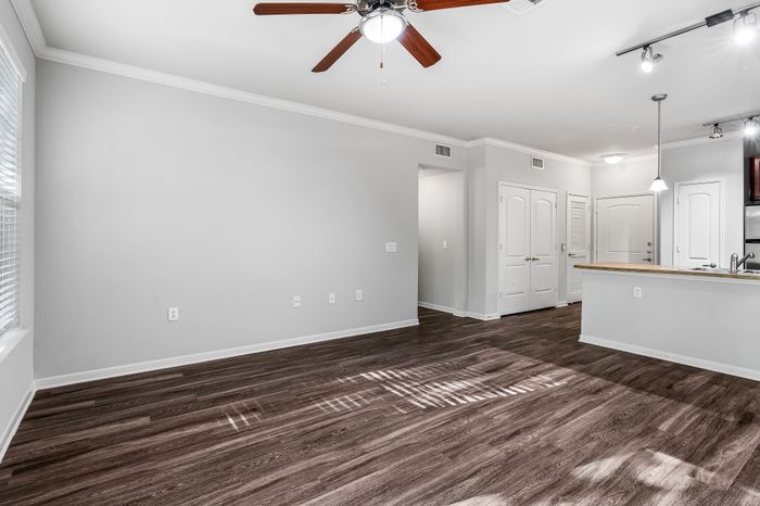 Modern open-concept apartment with sleek hardwood floors, recessed lighting, and a spacious kitchen island.