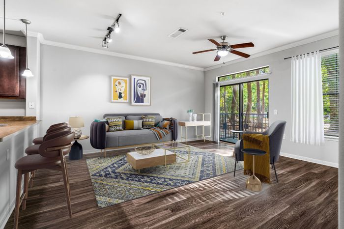 Elegant modern living room with stylish decor, featuring a comfortable gray sofa, chic artwork, and a cozy balcony view.