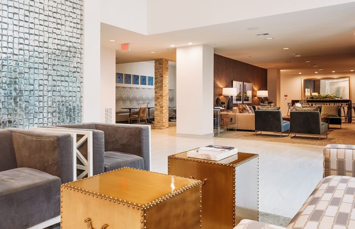 Luxurious lobby featuring contemporary seating arrangements, stylish decor, and elegant lighting in a spacious apartment complex.
