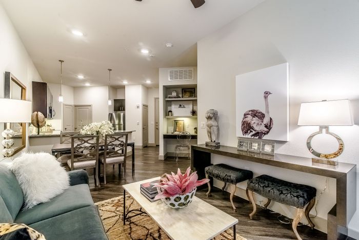 Elegant open-concept living space with stylish decor, comfortable seating, and a modern dining area in a well-lit apartment.