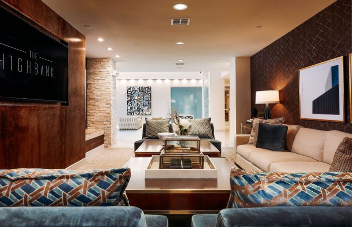 Elegant and inviting living room with chic decor, featuring plush sofas, stylish cushions, modern art pieces, and warm lighting in a luxurious apartment setting.