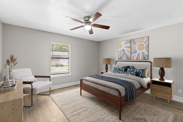 Elegant bedroom featuring a wooden bed with chic linens, modern armchair, and warm lighting, offering a cozy and stylish retreat.