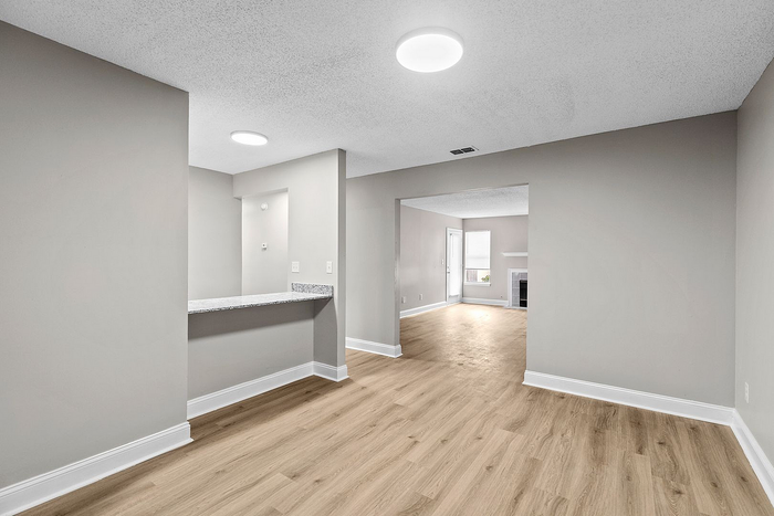 Modern open-concept apartment interior featuring sleek hardwood floors and elegant recessed lighting.