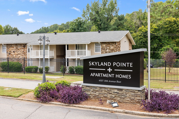 Inviting exterior view of Skyland Pointe Apartment Homes with lush landscaping and charming architecture.