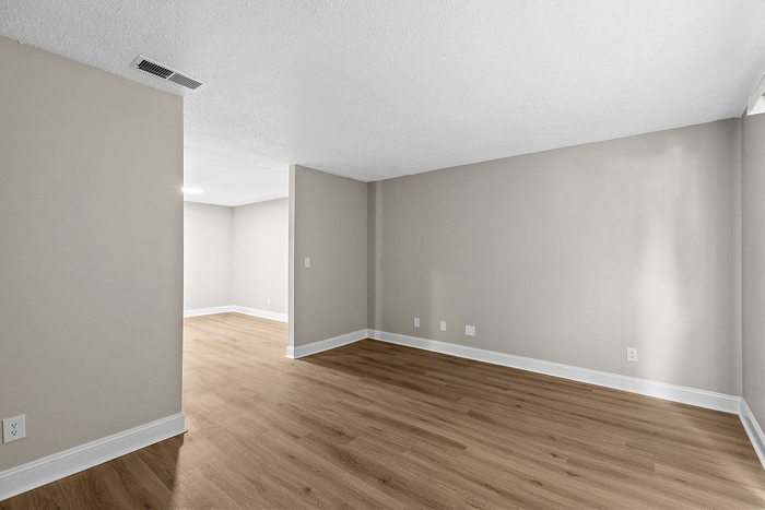 Elegant open-concept living space with modern wood flooring and neutral walls, perfect for versatile interior design.