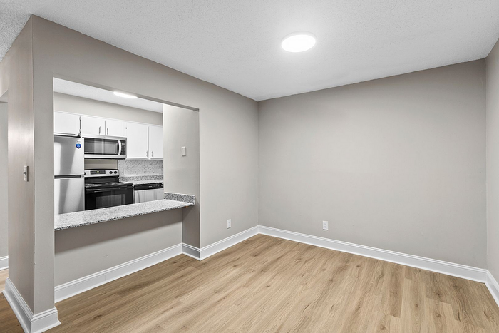 Modern open kitchen view with stainless steel appliances and elegant hardwood flooring.