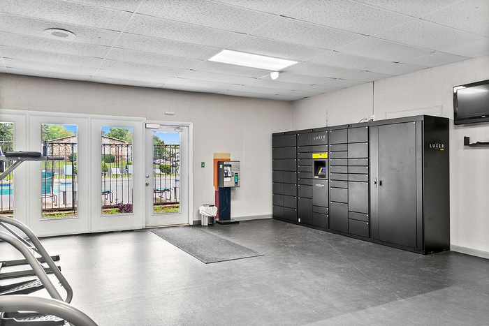 Modern apartment amenities featuring secure Luxer package lockers and bright interiors with a view of the outdoor pool.