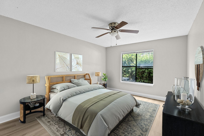 Elegant bedroom with a cozy bed, stylish decor, and a large window offering a scenic garden view.