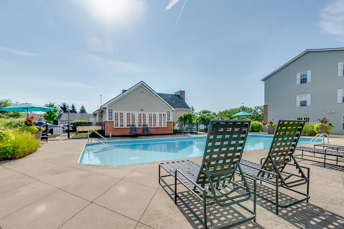 Inviting outdoor pool area with comfortable lounge chairs and vibrant greenery, perfect for relaxation and leisure.