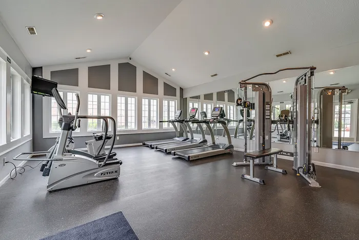 Modern fitness center with state-of-the-art equipment, featuring treadmills, exercise machines, and a sleek, mirrored design for an inspiring workout experience.