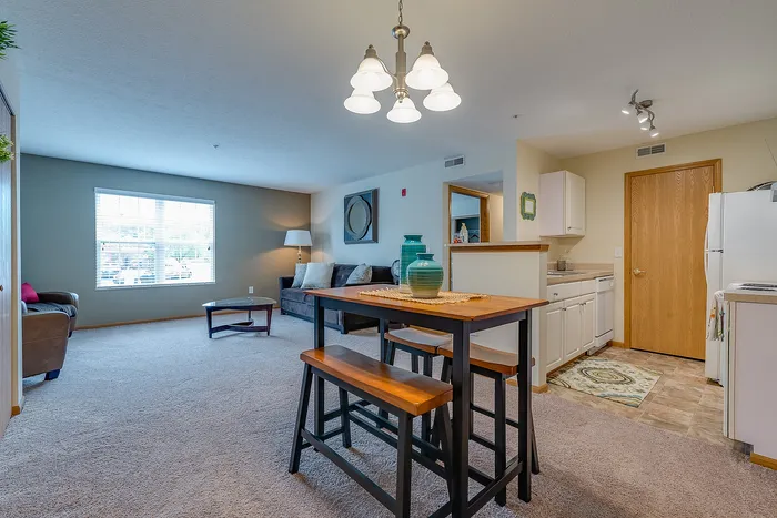 Inviting open-concept living space with natural lighting, featuring a cozy living room, stylish dining area, and a modern kitchen.