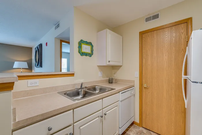 Bright and inviting kitchen with modern fixtures, a double sink, sleek countertops, and ambient lighting, perfect for culinary adventures.