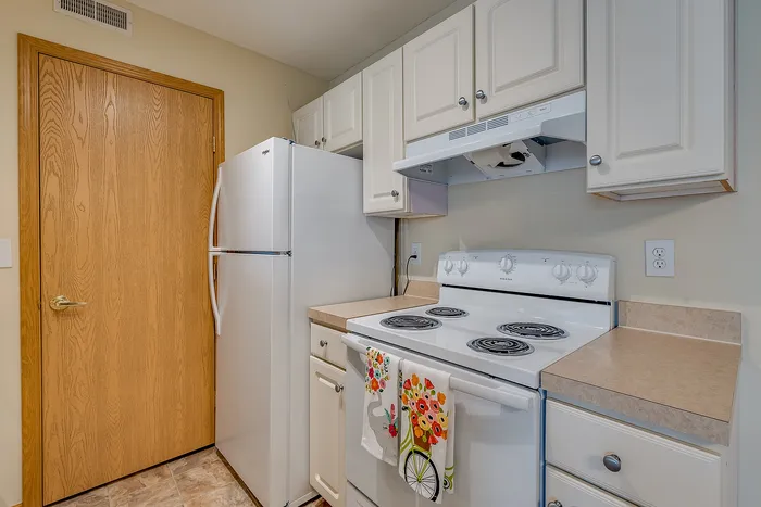 Charming kitchen with white cabinetry, modern appliances, and vibrant floral decor.