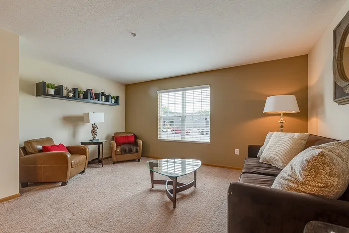 Inviting living room with plush brown seating, stylish decor, and natural light streaming through a large window.