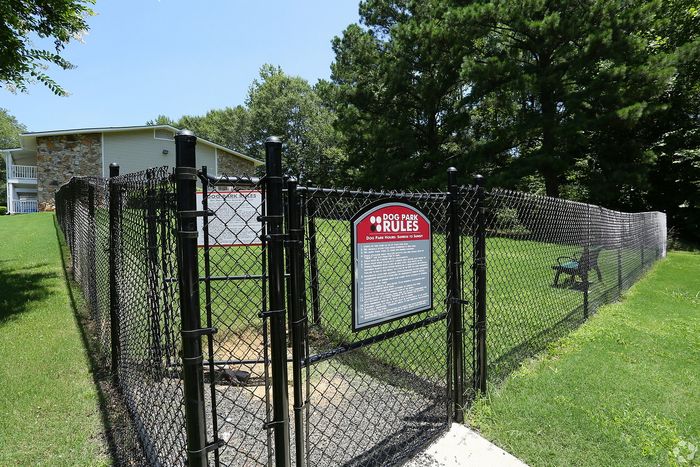 Inviting dog park with secure fencing and a lush green lawn, perfect for pets in a friendly community setting.