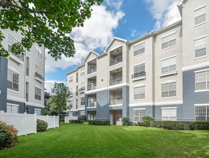 Charming apartment complex with contemporary architecture, featuring lush green lawns and inviting balconies.