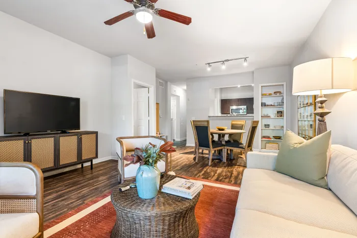 Chic living room with modern furnishings, elegant dining area, and open-concept kitchen featuring sleek appliances and a cozy ambiance.