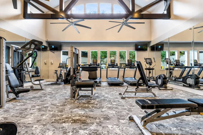 Modern fitness center with state-of-the-art equipment, large windows, and sleek design.