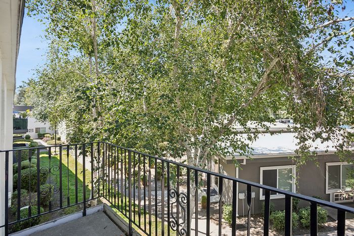 Charming balcony overlooking lush greenery and a peaceful courtyard for a serene living experience.