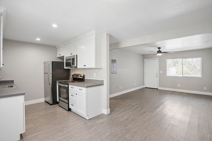 Chic open-concept kitchen and living space with modern appliances, sleek cabinetry, and elegant wood flooring.